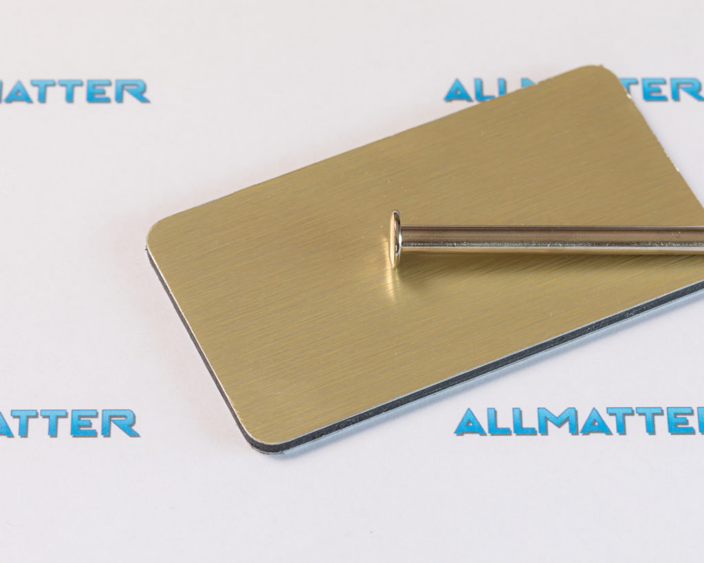 Złota blacha z metalowym prętem na tle z logo Allmatter