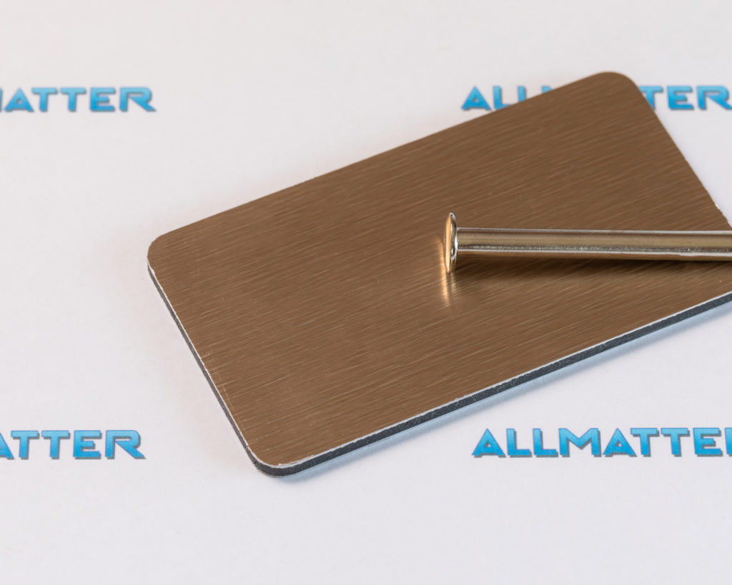 Metalowa płytka z metalowym gwoździem na tle z napisem Allmatter