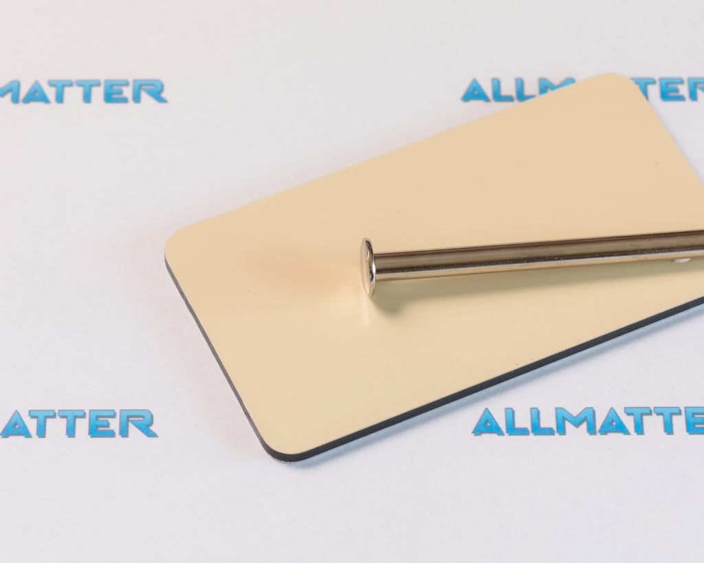 Metalowy pręt leży na jasnej, prostokątnej powierzchni