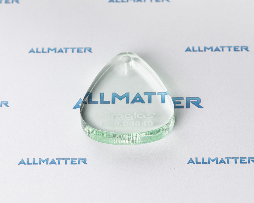 Bezbarwna pleksi w kształcie kropli na tle z logo Allmatter